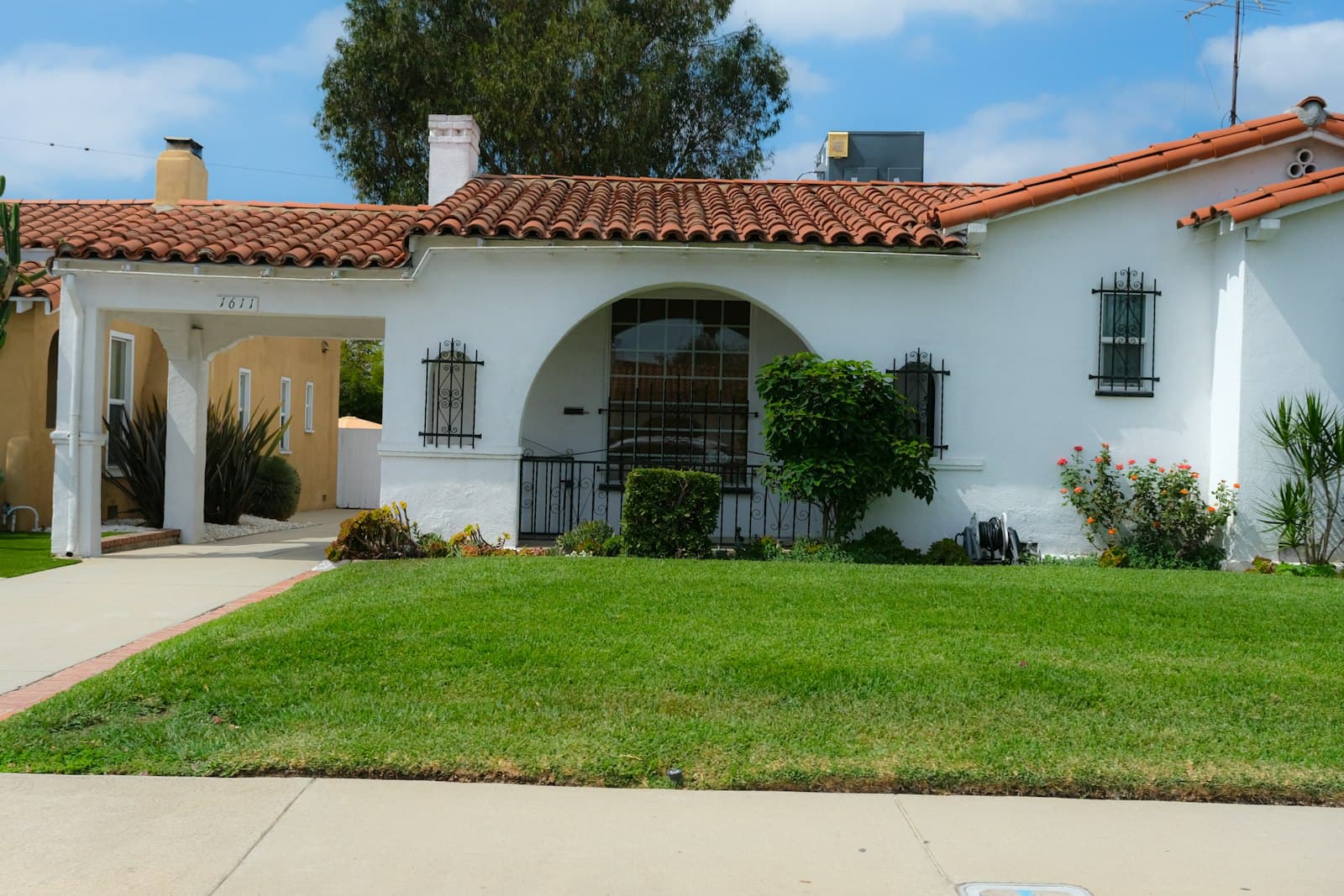 A well-kept Spanish-style single-family home with a green lawn